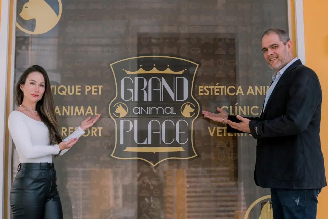 Sócios da Grand Animal Place diante do painel com o logo da marca
